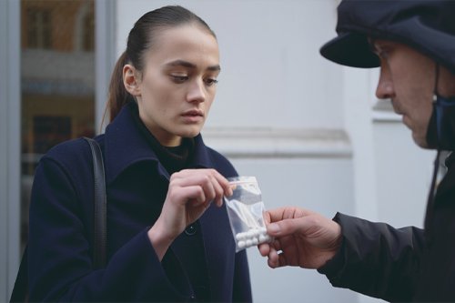 Девушка берёт у мужчины пакетик с таблетками
